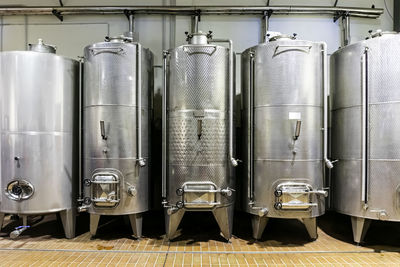 Metal silos for the fermentation of wine inside a farm. storage of wine in the cellar.