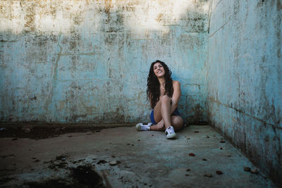 Young woman sitting at abandoned building