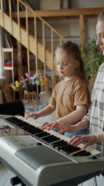 Mother and daughter playing piano