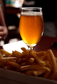 Close-up of french fries and drink on table