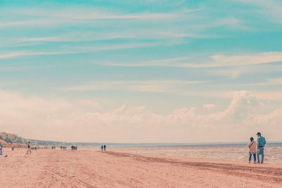 People at beach against sky