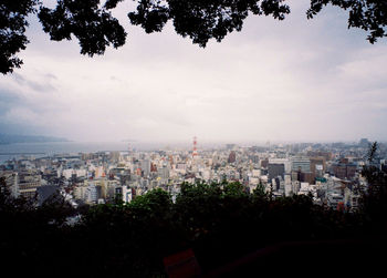 Buildings in city against cloudy sky