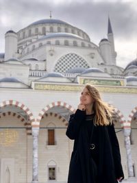 Full length of a woman standing outside temple