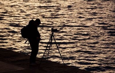 Silhouette man photographing at beach