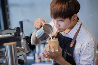 Full length of boy drinking coffee in glass