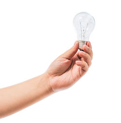 Close-up of hand holding light bulb against white background