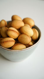 Close-up of peanuts in bowl on white background