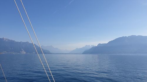 Scenic view of sea and mountains against blue sky