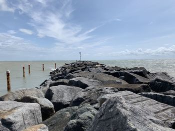 Rocks on sea shore against sky