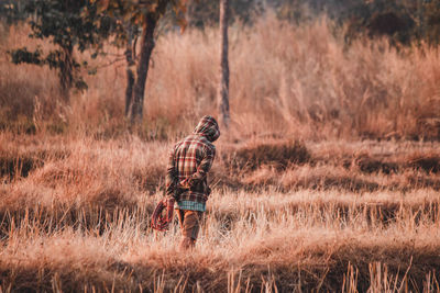 Rear view of man walking on field