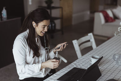 Smiling female entrepreneur on video call through laptop at home