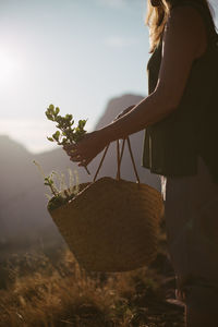 Midsection of woman with bag standing on land