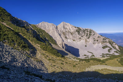 Scenic view of rocky mountains against clear blue sky