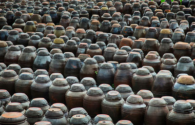Full frame shot of metallic barrels arranged on field
