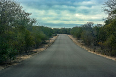 Road amidst trees against sky