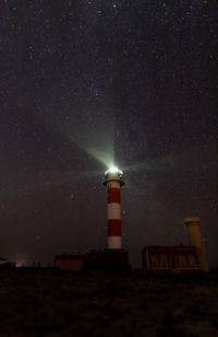 Low angle view of lighthouse against sky at night