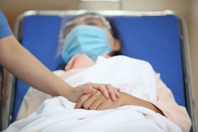 Cropped hand of doctor consoling patient at hospital