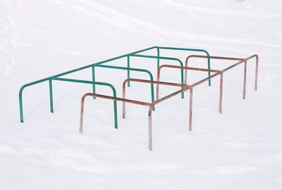 Close-up of empty railing against snow covered wall