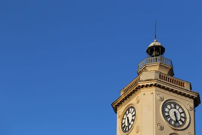 Low angle view of clock tower against clear blue sky