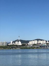 View of buildings in city against clear blue sky