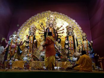 Rear view of priests worshiping goddess durga during festival