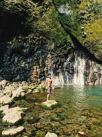 Fit guy posing on a rock next to the river