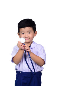 Portrait of smiling boy standing against white background