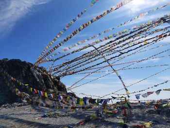 Low angle view of multi colored prayer flags against sky