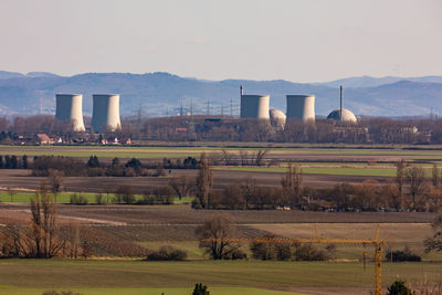 A nuclear power plant with multiple cooling towers and power poles to generate electricity