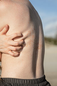 Midsection of man with arms crossed