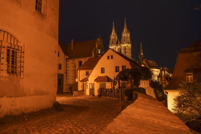 Street amidst buildings in city at night