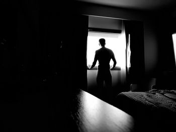 Rear view of silhouette man standing in corridor