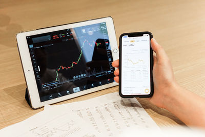 Close-up of man using smart phone on table