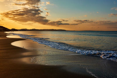 Scenic view of beach against sky during sunrise