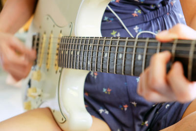 Midsection of man playing guitar