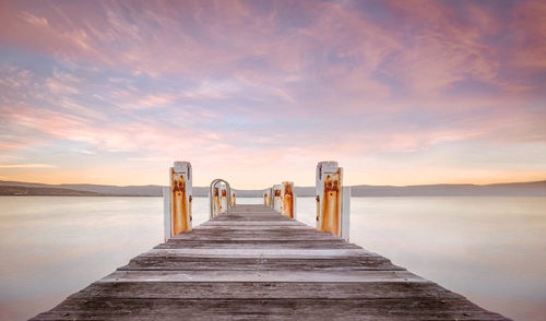 Surface level of pier over sea against sky