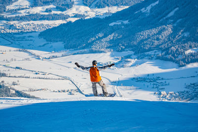 Rear view of man snowboarding on mountain