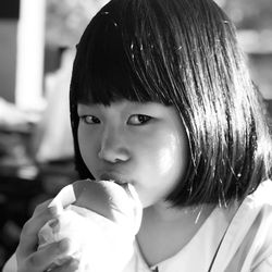 Close-up portrait of cute girl eating burger