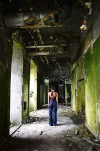 Rear view of people standing in abandoned building