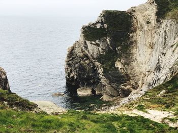 Rock formations by sea against sky