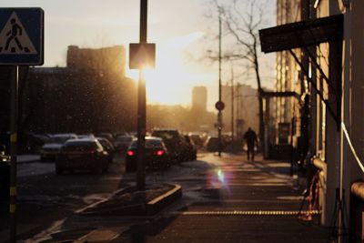 Cars on road in city during sunset