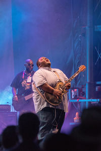 People playing guitar at music concert