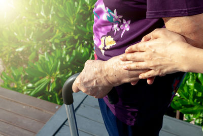 Midsection of couple holding purple outdoors