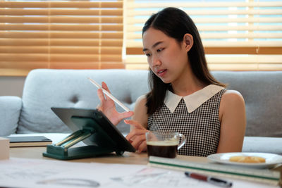 Young woman using laptop at table