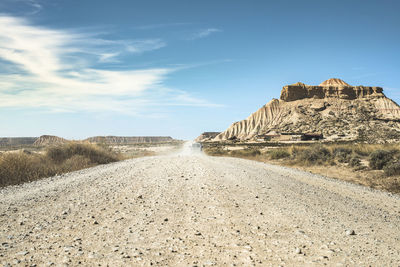 Rock formations on road against sky