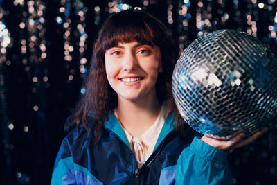 Portrait of young woman holding christmas tree