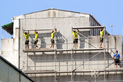People working at construction site against clear sky