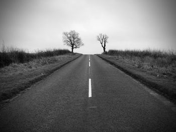 Road amidst trees against sky