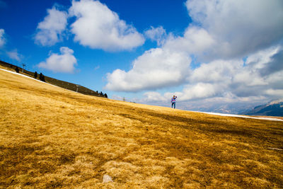 Man walking on field against sky