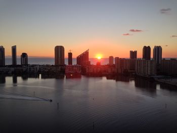 View of city at waterfront during sunset